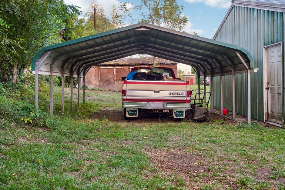 Metal carport sheltering a pickup truck on a rural property, representing metal carport installation in Columbia, SC